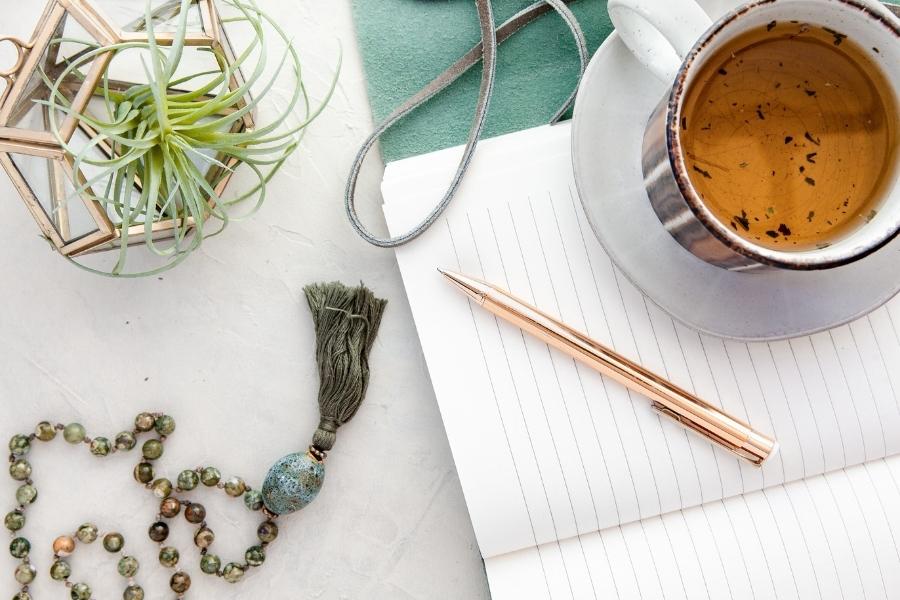 Abnehmen in den Wechseljahren: Tasse Tee und Notizbuch für die Morgenroutine